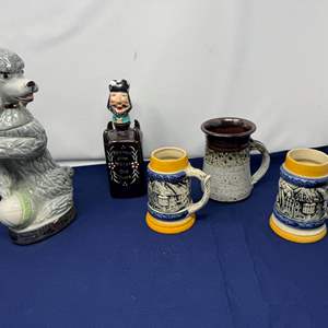 Lot #190 - Vintage Jim Beam Poodle Decanter, Hand Painted Glass Vodka Decanter, Two German Beer Mugs & More