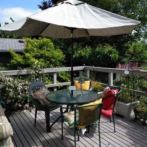 Lot # 170 - Patio table (41 diam) with umbrella, 4 mix-match chairs, pillows, candle lantern