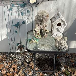 Lot #311 - Garden decorations and small glass-top table