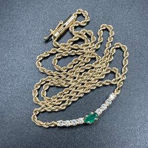 Lot #9 - 14 karat gold rope chain with center .15c emerald stone and .25c diamonds (6.8g)