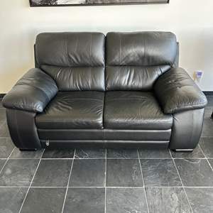 Lot #102 - Black leather loveseat