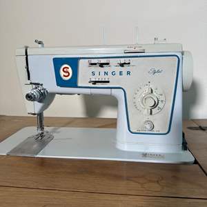 Lot #329 - Singer, sewing machine with storage table and chair