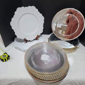 Lot #101- Collection of Chargers: White Plastic Doily, Silver Colored Metal Chargers, Clear Plastic Chargers